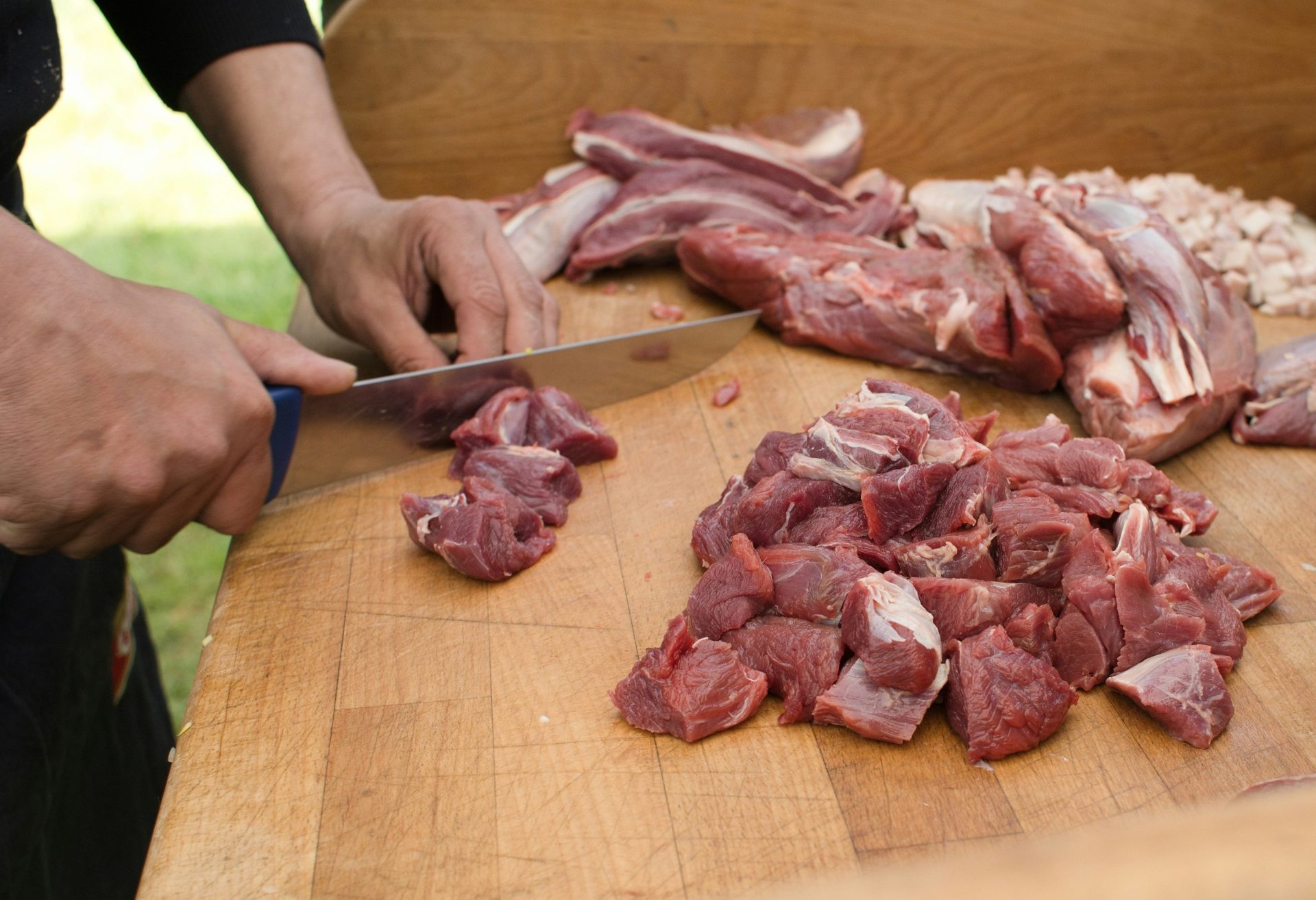 Eine Person zerkleinert Fleisch auf einem Schneidebrett